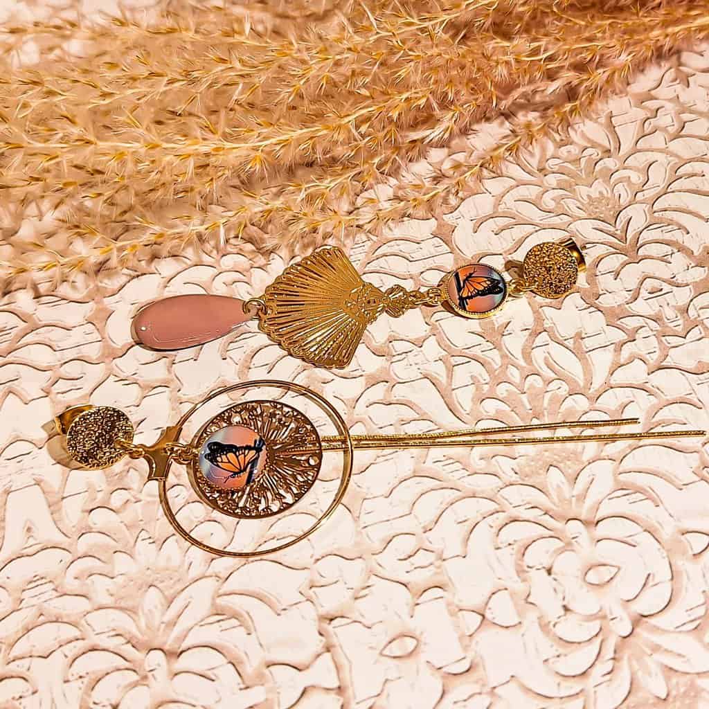 Boucles papillon pampilles asymétriques faites-main avec pendentifs dorés et illustration aurore boréale