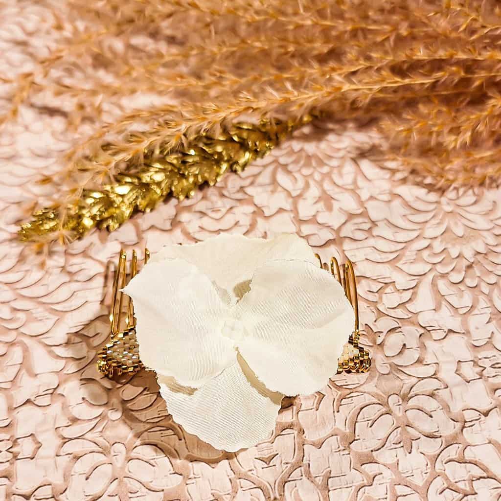 Gros plan sur les médaillons en perles japonaises tissées et la fleur d’hortensia en tissu du peigne