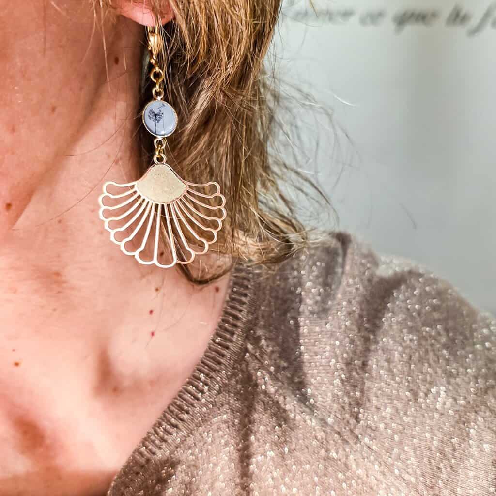 Boucles dandelion nature végétale resin feuille tropicale lydee deco (2) Boucles Dandelion bleues et dorées – Bijoux fleurs fait-main en laiton doré 24K, boucles d’oreilles légères inspirées par la nature, cadeau original femme. photo portée