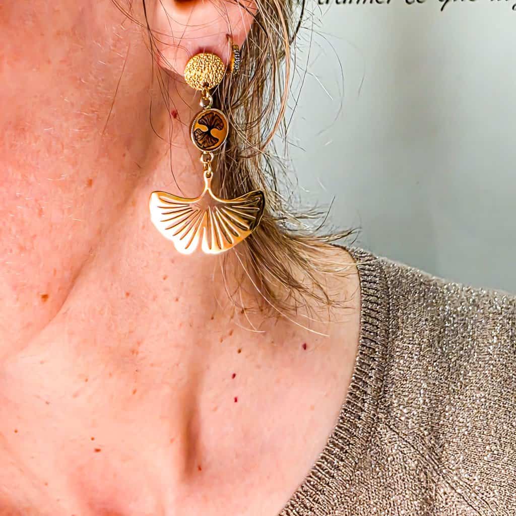 Boucles ginkgo doré resine boheme chic lydee deco (5) Gros plan sur le médaillon rond en laiton doré 24K orné d’une illustration éventail ginkgo noir photo portée