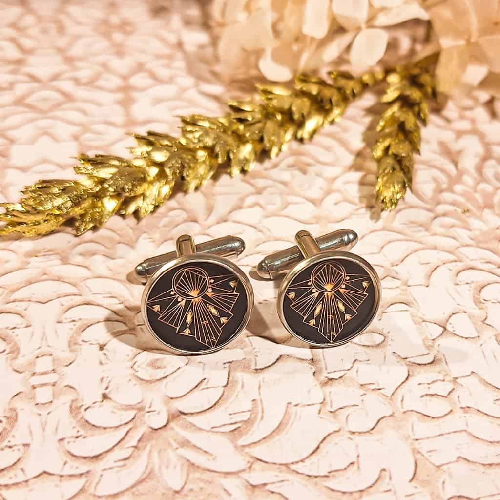 Boutons de manchettes dorés portés sur une chemise blanche pour un look chic et élégant.