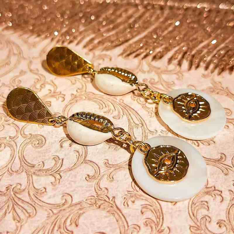 Gros plan sur la finition dorée et la nacre des boucles coquillage
