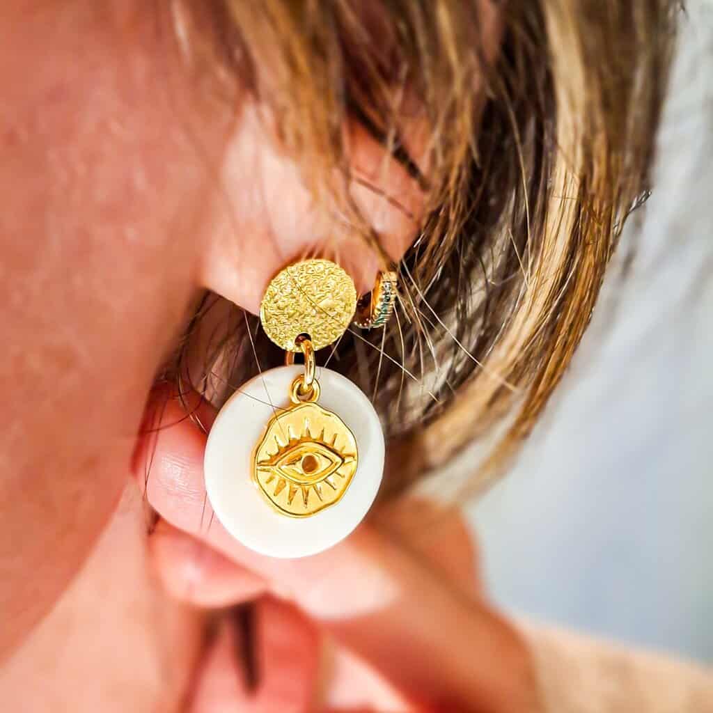 Zoom sur les boucles oeil nacre : pendentif en nacre irisée, attaches acier inoxydable