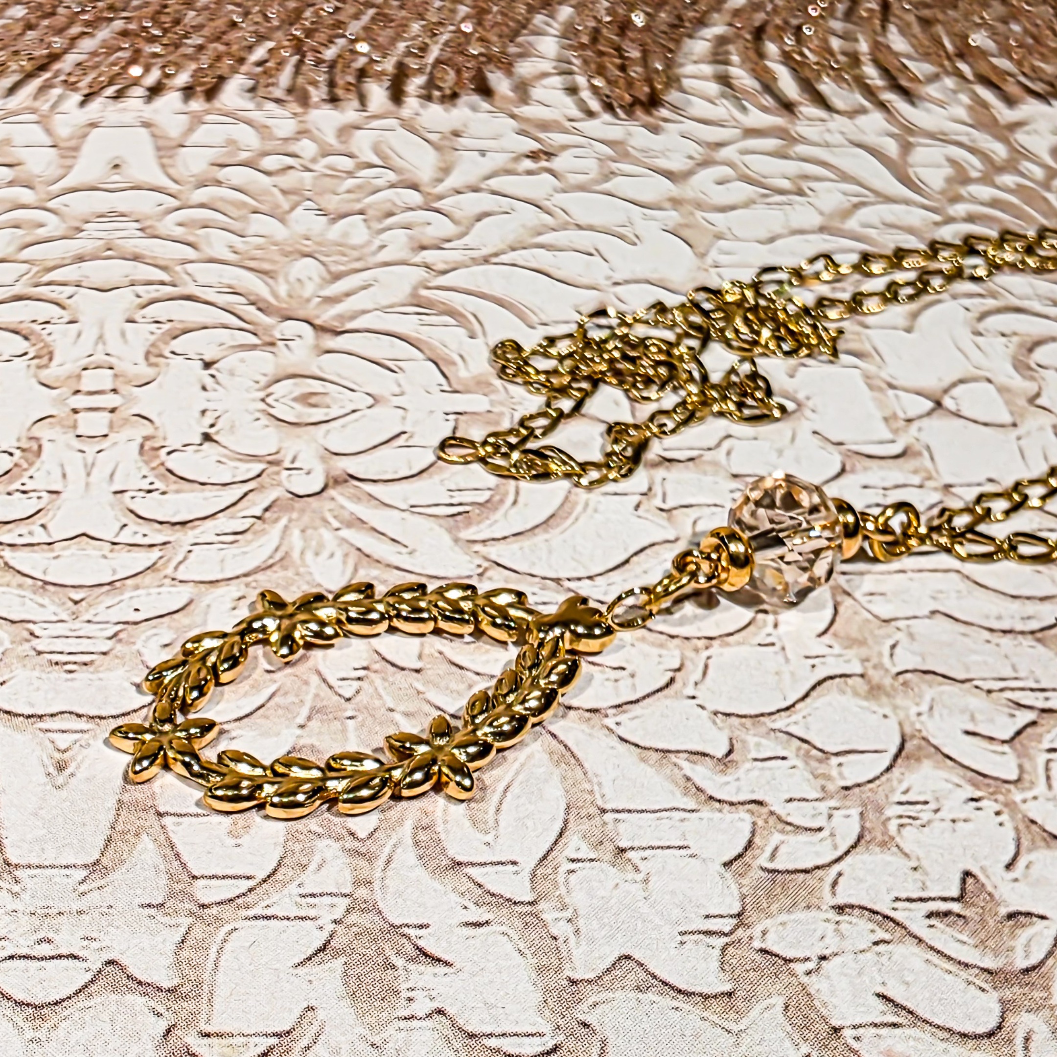 Collier couronne de laurier en acier inoxydable avec pendentif feuilles détaillées et perle en verre facettée irisée rose