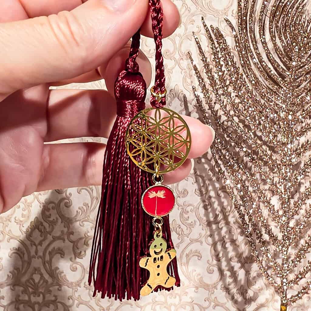 Zoom sur le marque-pages pain d’épice fait main en résine, détail du motif et du sequin scintillant, accessoire de lecture cosy pour amoureux des livres