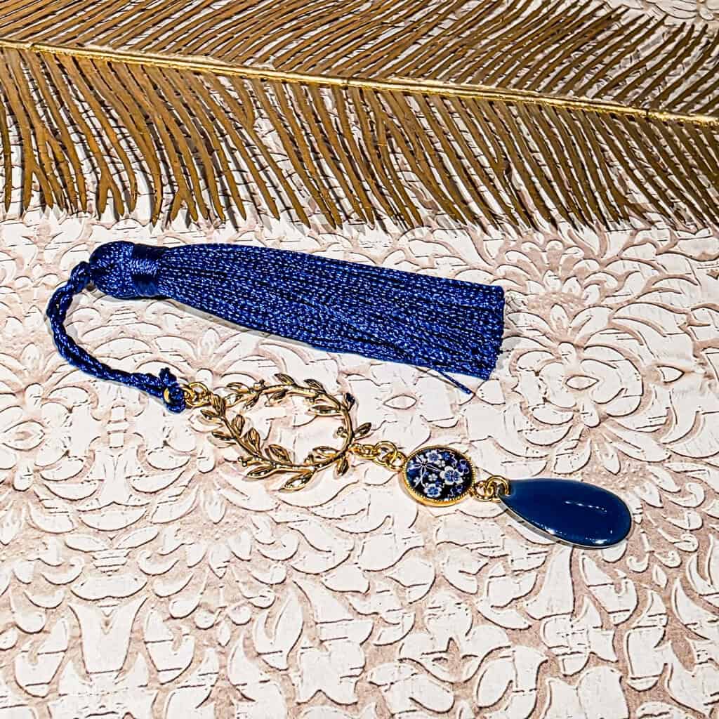 Marque-page bleu avec médaillon résine fleuri, fleur de cerisier tons bleus blanc dorés, pompon textile fait main