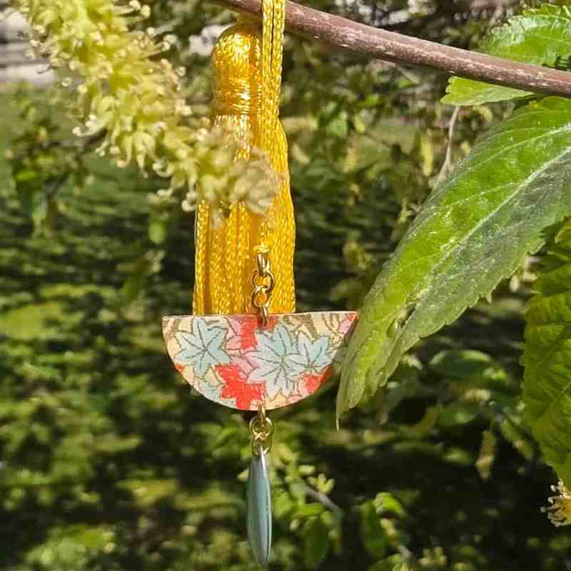 Marque-pages printemps fait-main – Bijou de livre unique avec pompon jaune soleil et pendentif demi-lune en papier japonais verni aux motifs feuilles pastel