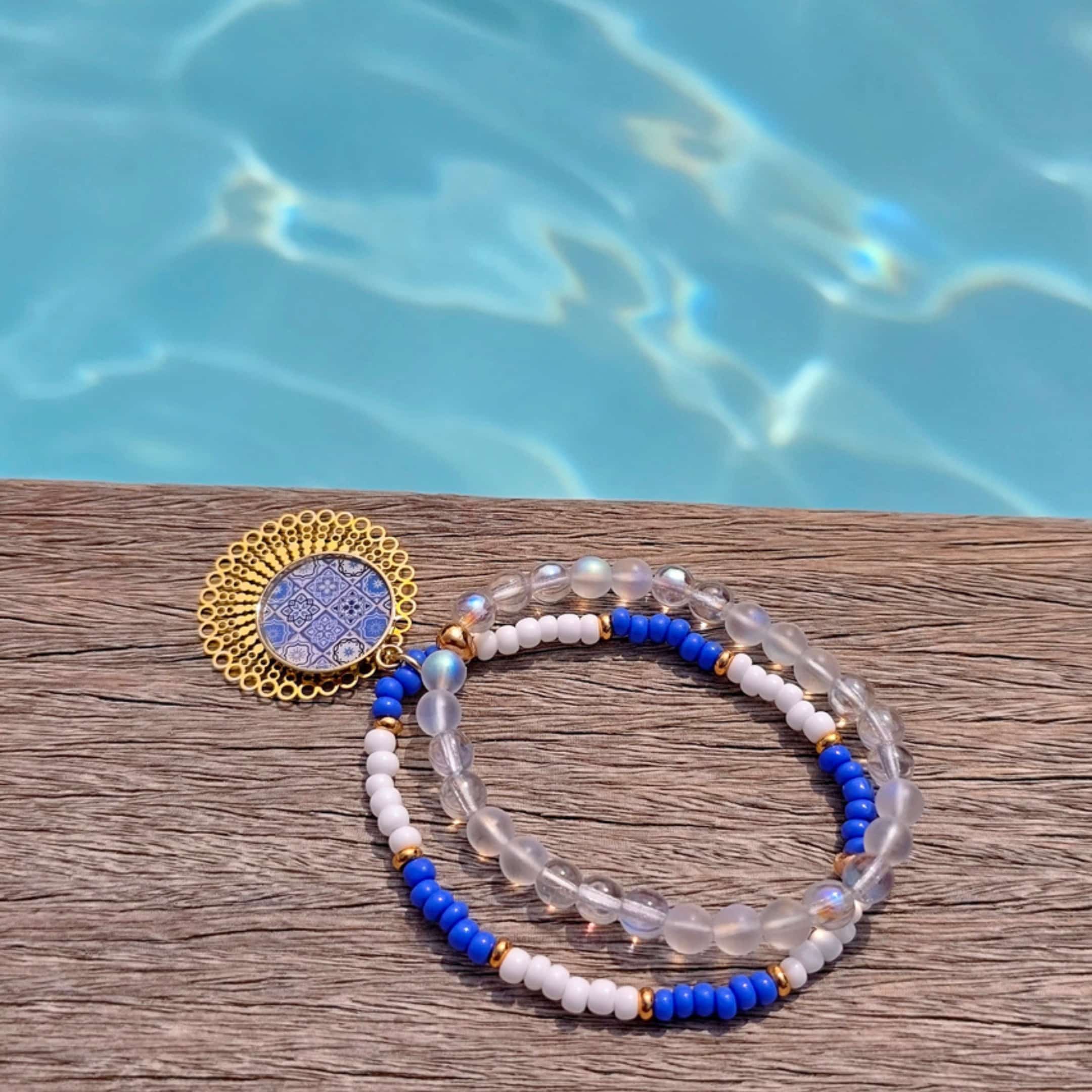 Bracelet bleu azur fait-main, médaillon rond en résine et papier photo 25 mm sur estampe laiton dorée, perles bleu blanc irisées – Lydée Déco